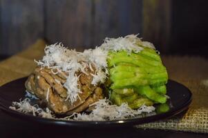 Textured, made from processed cassava that is steamed and mashed. Served with grated coconut. photo