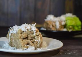 Textured, made from processed cassava that is steamed and mashed. Served with grated coconut. photo