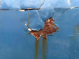 rusty blue plate with peeling paint of cat door, abstract background, texture photo