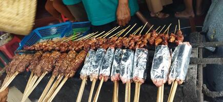 Defocused of Sate Buntel or Satay Buntel is satay made from minced mutton wrapped in mutton fat is being grilled on charcoal photo