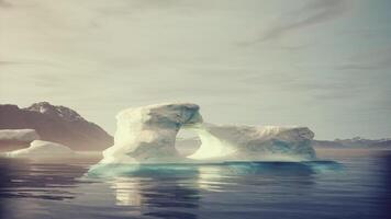 A large iceberg floating in the middle of a body of water video