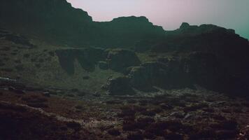 A view of a rocky mountain with a sky in the background. mountain path video