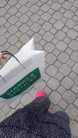 Prague, Czech republic - October 2, 2023. A person walks on a cobblestone path carrying a shopping bag of Marks and Spencer photo