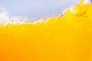 Close up bright orange juice splash texture for health and nature waves, Beautiful waves curve and little bubbles smooth for garphic design and background photo