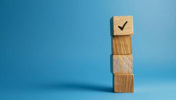 Stacked Wooden Blocks with Checkmark on Blue Background with Copy Space photo