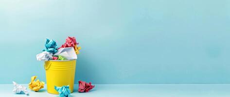 Colorful Trash in Bucket on Blue Background with Copy Space. Paper Bin Full of Crumpled Colorful Papers photo