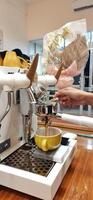 Close up Barista making coffee for customer in cafe. Woman working in coffee shop wearing an apron. Makassar, South Sulawesi, Indonesia - August 11 2024 photo