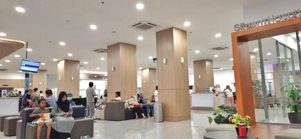 Atmosphere of patient queues to receive medical services at waiting area hospital. Makassar, South Sulawesi, Indonesia - August 12 2024 photo
