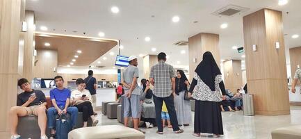 Atmosphere of patient queues to receive medical services at waiting area hospital. Makassar, South Sulawesi, Indonesia - August 12 2024 photo