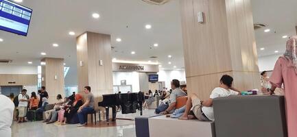 Atmosphere of patient queues to receive medical services at waiting area hospital. Makassar, South Sulawesi, Indonesia - August 12 2024 photo