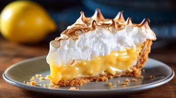 Slice of lemon meringue pie close up with golden brown meringue photo