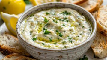 Creamy White Bean Dip in a Rustic Bowl, Garnished with Fresh Herbs, White Bread Slices in Background photo