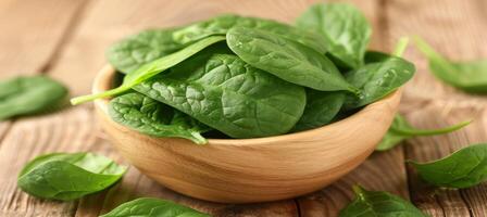 Fresh Organic Spinach Leaves in Wooden Bowl on Rustic Background, Healthy Food Concept photo