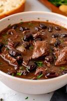 Brazilian Feijoada Stew with Black Beans, Beef Pork in white Bowl,. Traditional Recipe photo