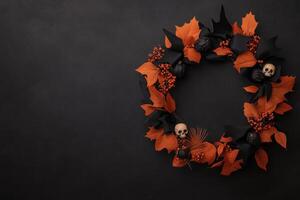 A spooky wreath made of black and orange ribbons, with small skulls and bats photo