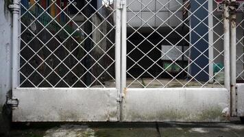 Old white metal gate on the side of the road. Mossy and grunge texture. photo