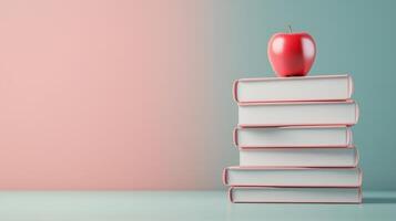A stack of white books with a red apple on top, set against a soft pastel background, symbolizing knowledge and education. photo