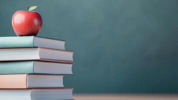 An inviting stack of books topped with a vibrant red apple against a soft blue background, symbolizing learning and education. photo