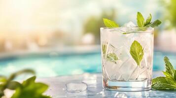 Refreshing cocktail with mint leaves and ice on a sunny day, ideal for summer relaxation by the pool. photo