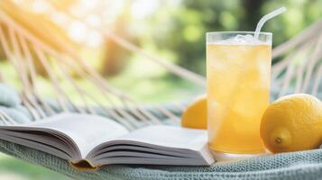 Refreshing drink and open book on a hammock, perfect for a sunny day. Enjoy relaxation and tranquility in nature's embrace. photo