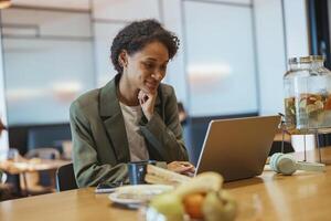 A whitecollar worker sits at a table using a laptop computer photo