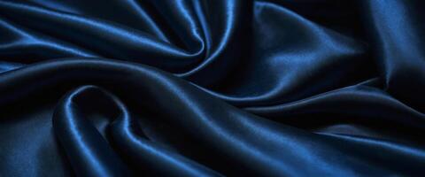 Beautiful dark blue silk satin background with soft folds on shiny fabric, luxury background with space for design, web banner, flat lay, top view. photo