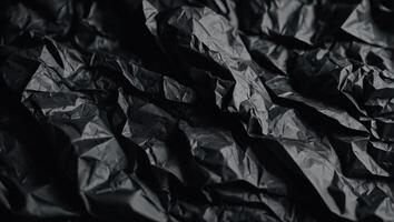 Black crumpled paper texture Crumpled black paper abstract shape background with space paper for text. photo