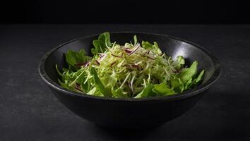 Bowls with mixed shredded salad lettuce fresh leaves, on black background, top view flat lay with copy space for text. photo