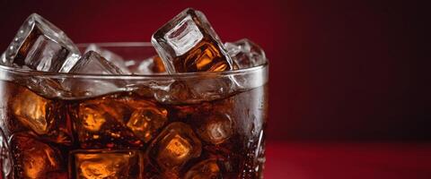 Cola with ice Fresh cold sweet drink with ice cubes Over red background with copy space. photo