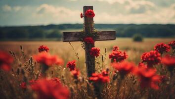 Cross with red flowers in the field, retro toned image. photo