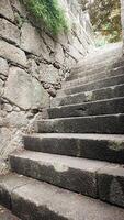 An ancient stone staircase leading upwards. The concept of a difficult rocky path to success, overcoming difficulties. photo