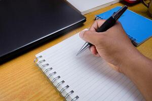 Hands holding pencils and notebooks. Hand with a pen is writing in a notebook. Mock-up Concept. photo