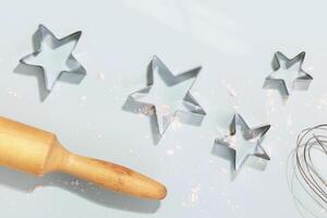Stars cookie cutters, rolling pin and whisk with flour photo