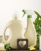 Detergent bottles, soap and lemon slices on wooden shelf photo