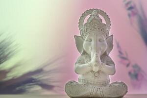 White sculpture of Lord Ganesha on a gradient background with copy space photo