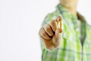 Boy holding gel capsule on a white background with copy space photo
