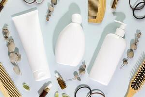 Shampoo and conditioner bottles with combs, mask for hair, oil, and eucalyptus photo