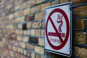 A prominent No Smoking sign displayed against a colorful brick wall, conveying a clear anti-smoking message in a public space. photo