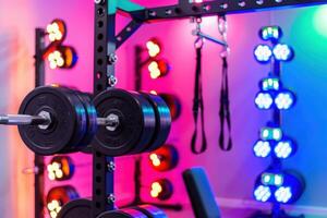 A high-tech home gym showcases colorful lighting and modern workout tools, creating an engaging atmosphere for fitness enthusiasts. photo