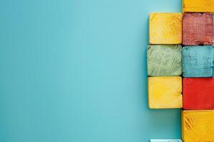 Colorful wooden blocks neatly positioned against a vibrant blue backdrop, creating a playful and artistic display. photo