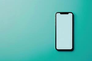 A sleek smartphone rests on a calm teal surface, showcasing a blank screen ready for personalization and creativity. photo