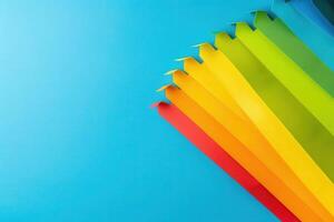 Colorful paper strips arranged in a gradient display energy efficiency ratings, creating a visually appealing representation against a smooth blue background. photo