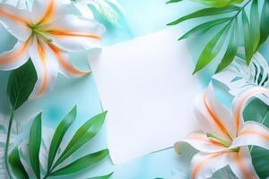 White Lilies and Green Palm Leaves with a Blank Card on a Blue Background photo