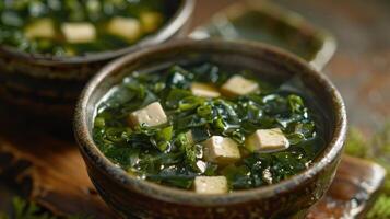 Close-up of a bowl of miso soup with tofu and seaweed photo