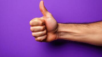 Hand Gesturing Thumbs Up on Purple Background photo