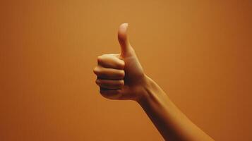 A Hand Giving a Thumbs Up Gesture Against an Orange Background photo