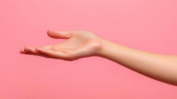 A Woman's Hand with Pink Nails Extended Outward Against a Pink Background photo