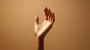 A Close-up of a Woman's Hand Reaching Upwards Against a Light Brown Background photo