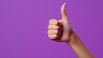 A Hand Giving a Thumbs Up Gesture Against a Purple Background photo