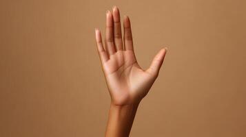 Open Palm with Long, Clear Nails Against a Tan Background photo